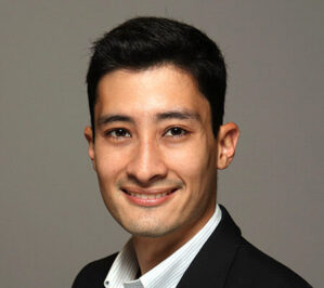 Dosdos, Christian James_final Headshot of a person with short dark hair wearing a dark blazer and a light-colored shirt, smiling at the camera.