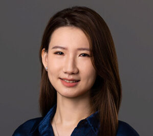 Guo, Yutong_final A professional headshot of a person with long brown hair, wearing a dark blue shirt, set against a neutral background.
